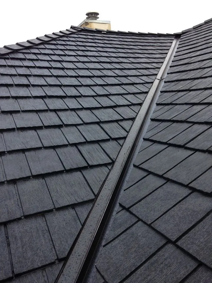 Designer shingles meeting in a valley, overlapping courses, no brand name.