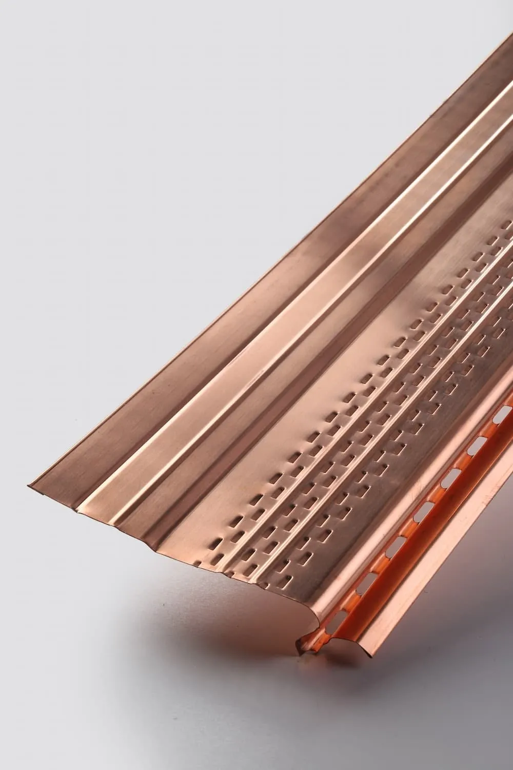 Copper gutter profile, half-round, no lettering, on a plain ground.
